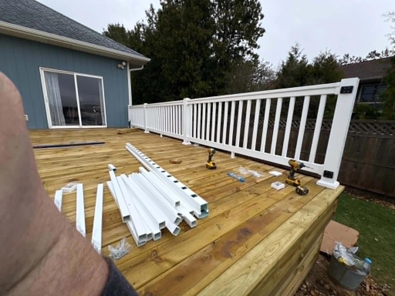 Deck railing installation in progress with materials staged on the new platform