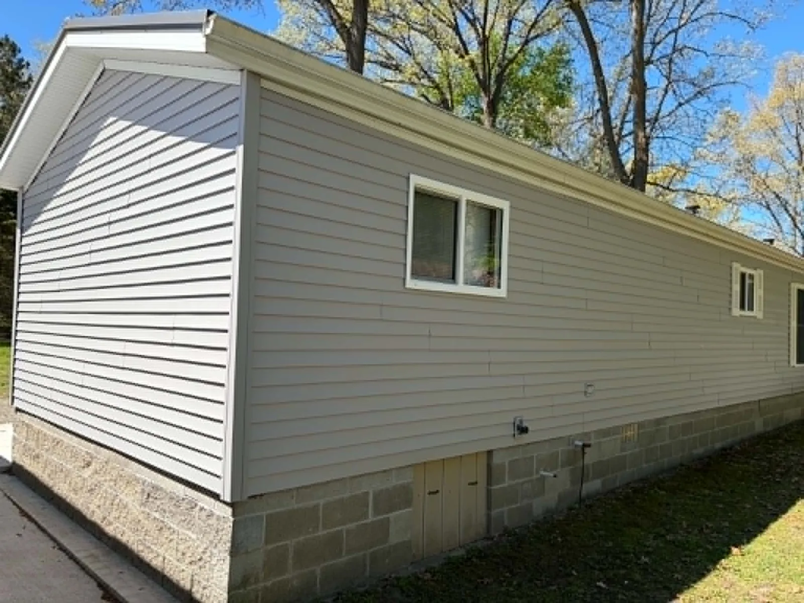 Long side elevation with new gray siding and white window trim