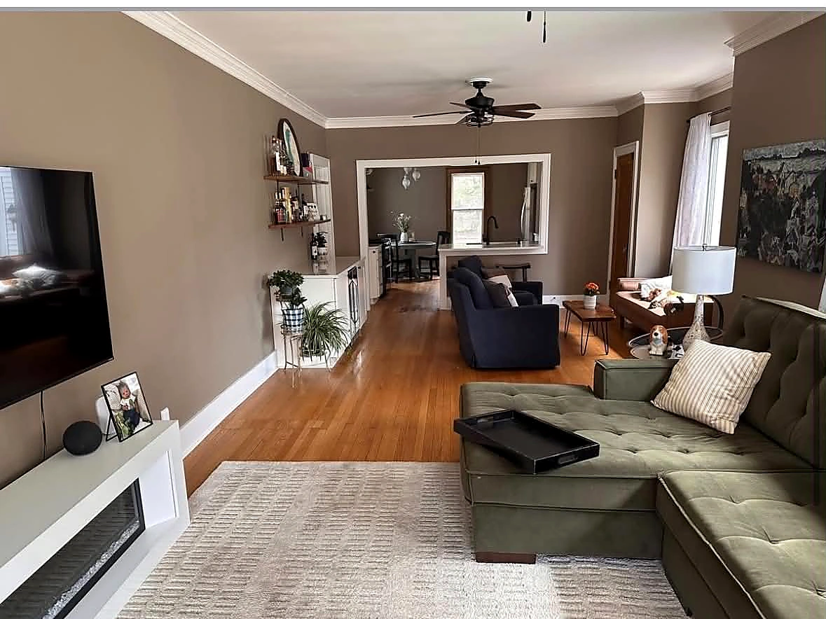Finished living room with a wide opening into the renovated kitchen and dining area
