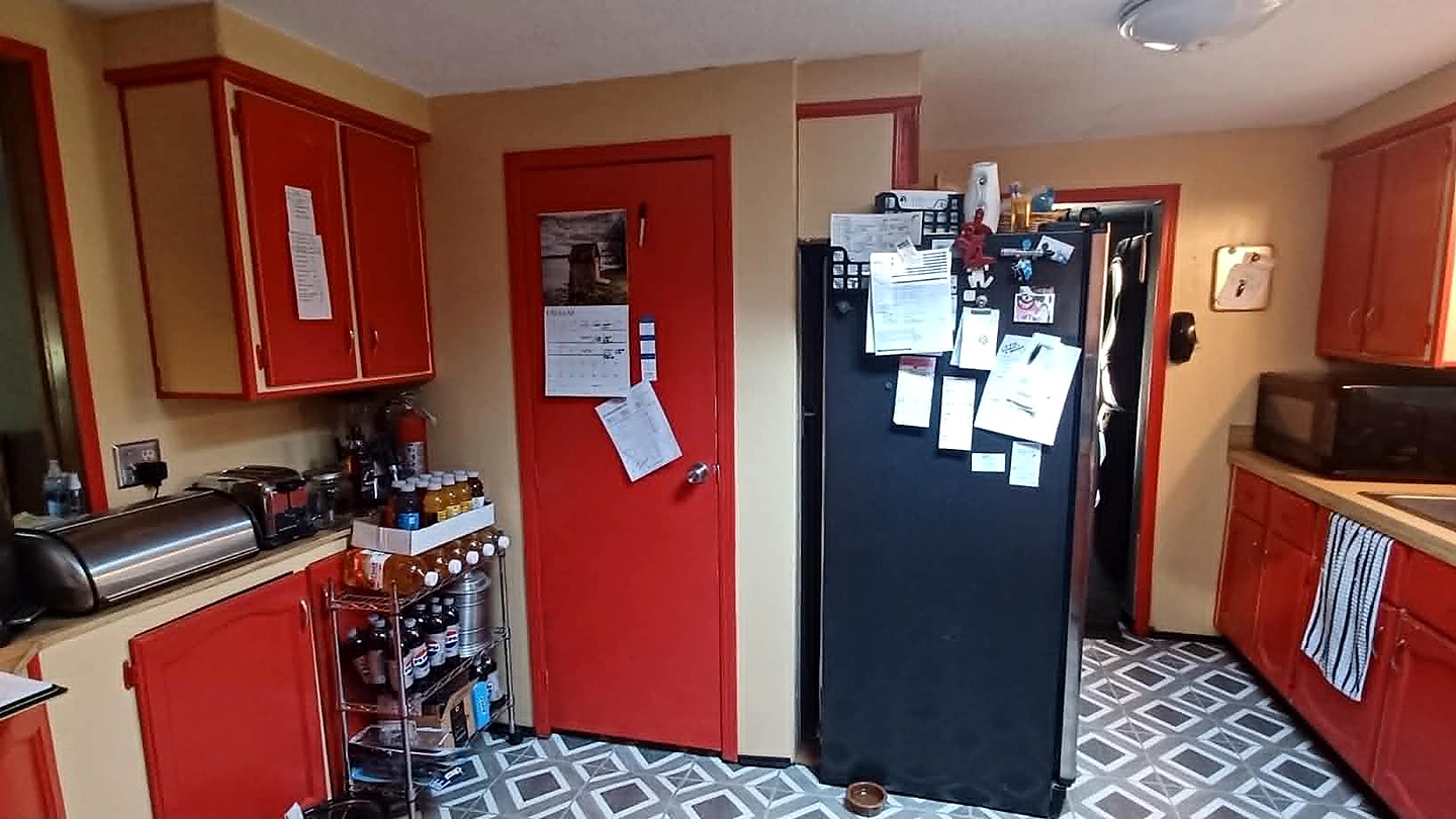 Kitchen before renovation with red cabinets, a closed layout, and patterned flooring