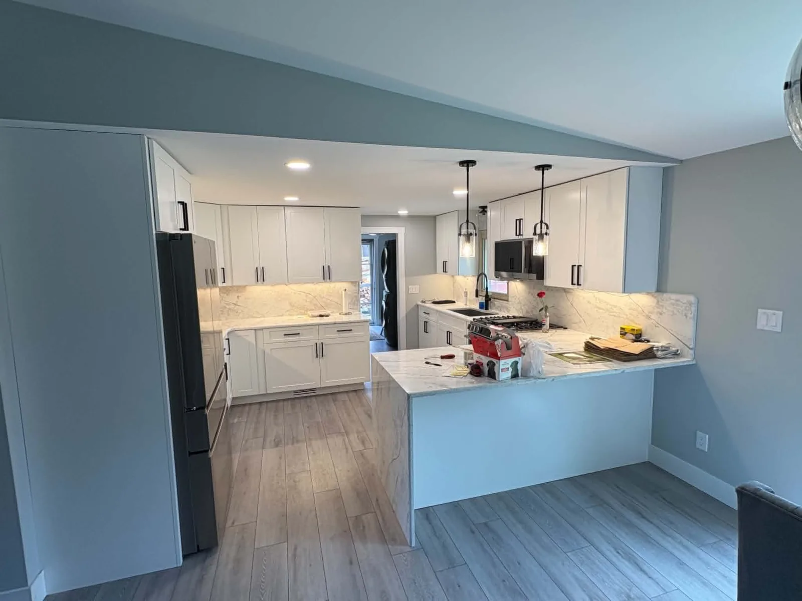 Finished kitchen with white cabinets, an island, and pendant lighting